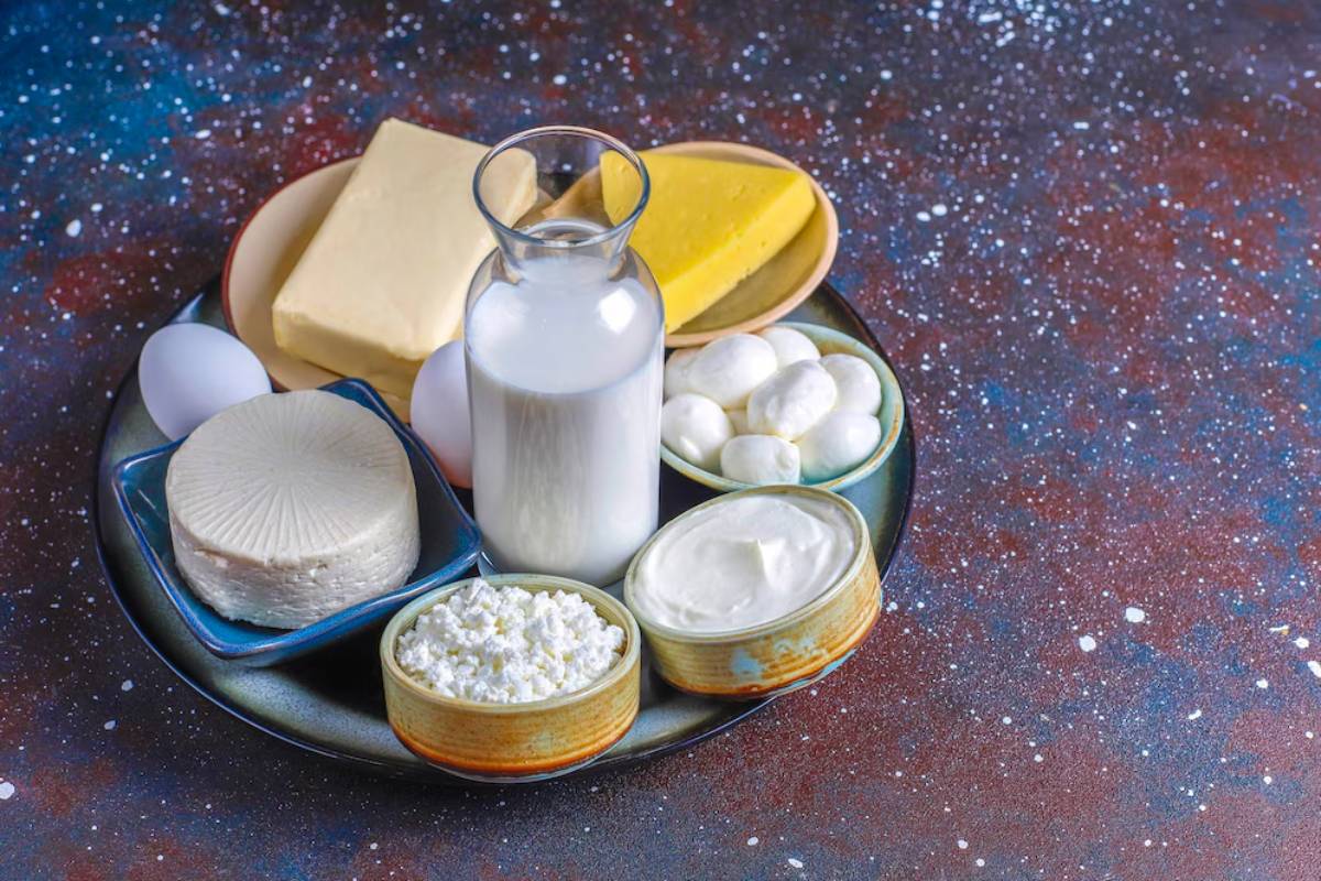 A variety of dairy products including cheese, milk, butter, and yogurt on a starry background.