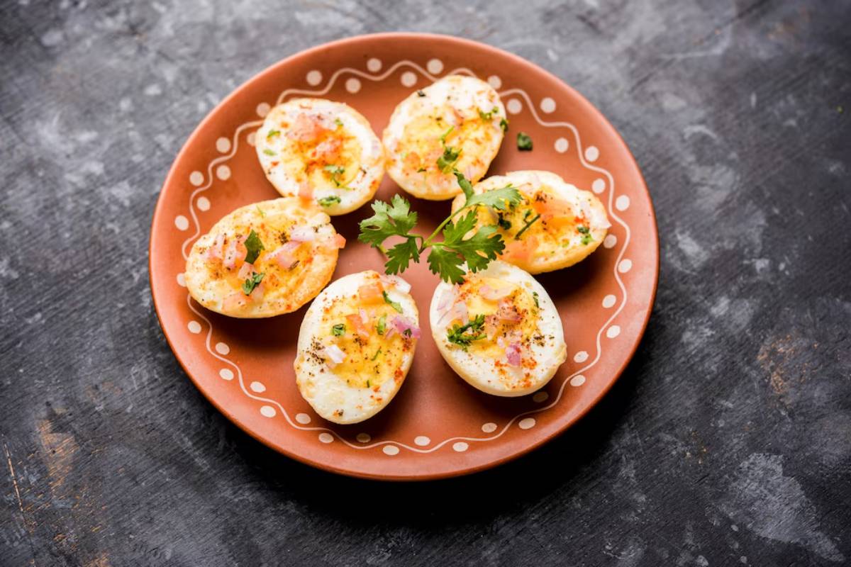 Plate of deviled eggs garnished with herbs and spices on a rustic table.